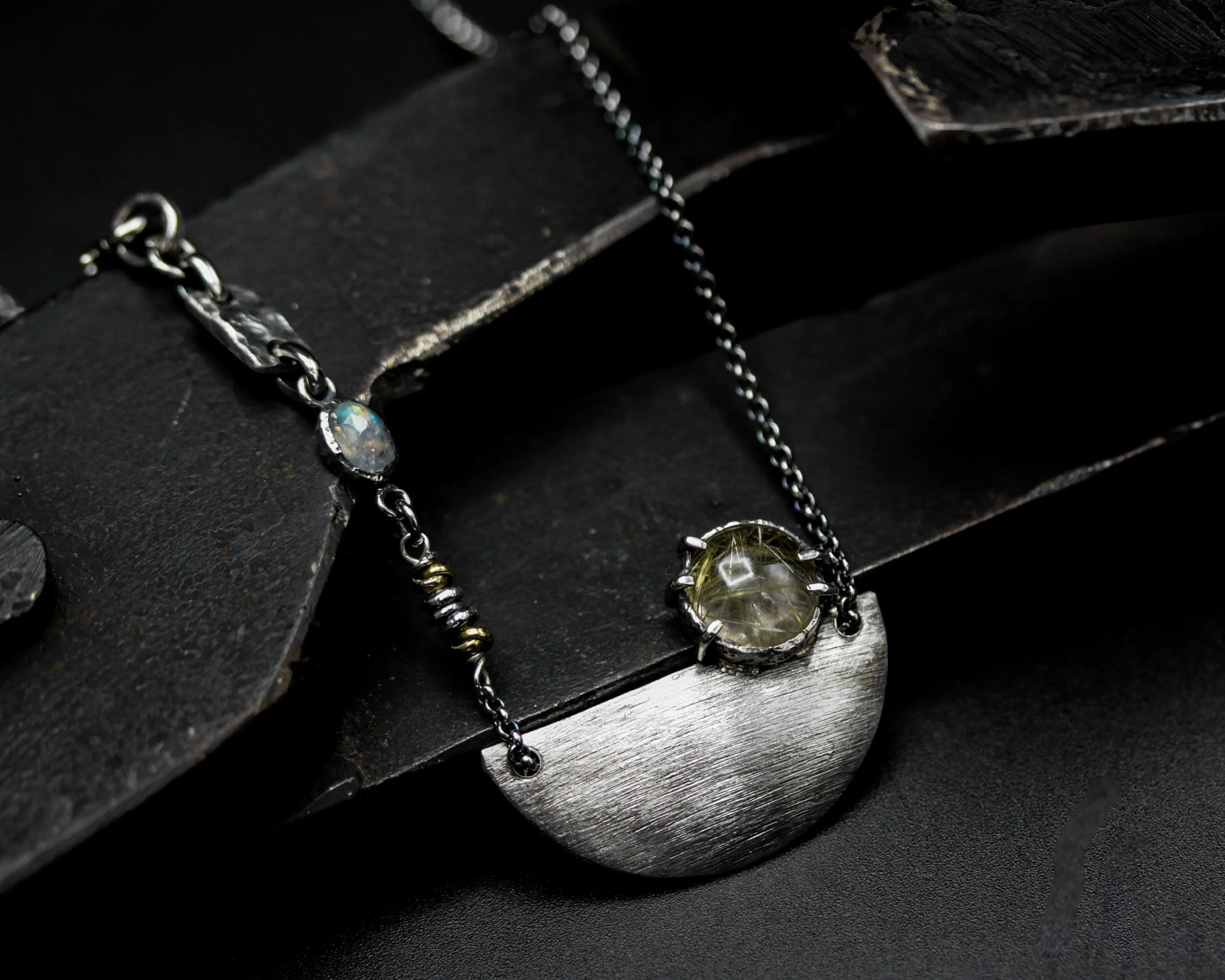Rutilated quartz cabochon pendant necklace with silver plate in semi-oval shape on sterling silver chain