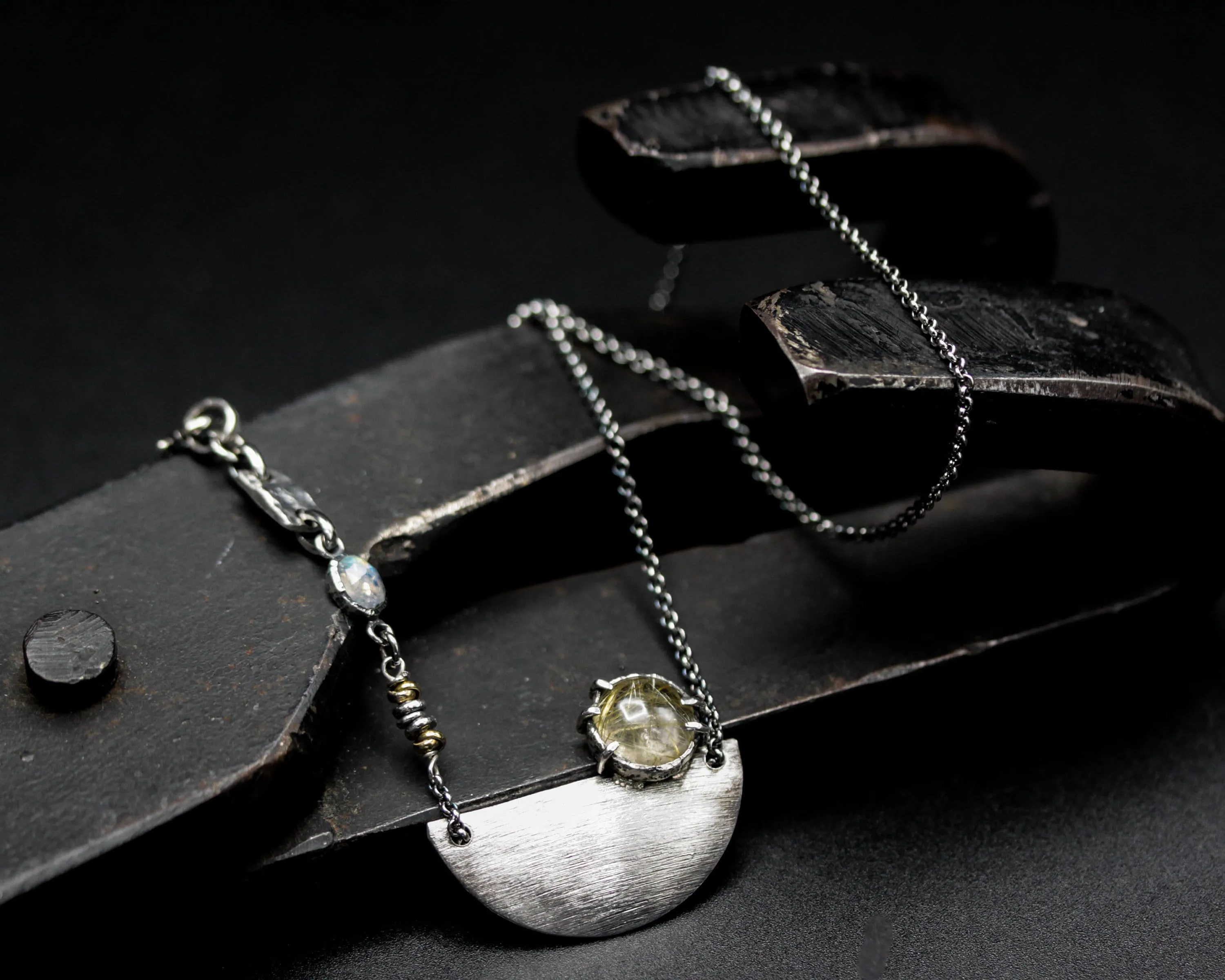 Rutilated quartz cabochon pendant necklace with silver plate in semi-oval shape on sterling silver chain