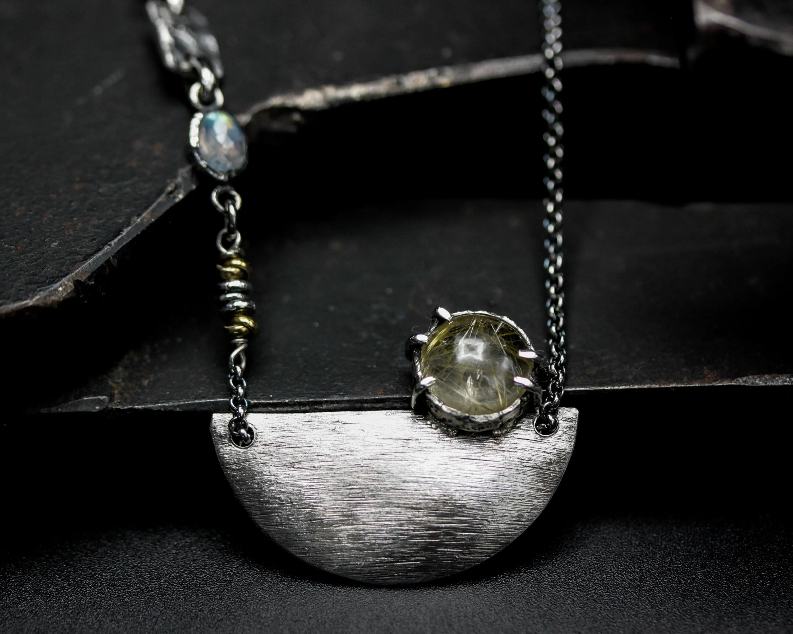 Rutilated quartz cabochon pendant necklace with silver plate in semi-oval shape on sterling silver chain